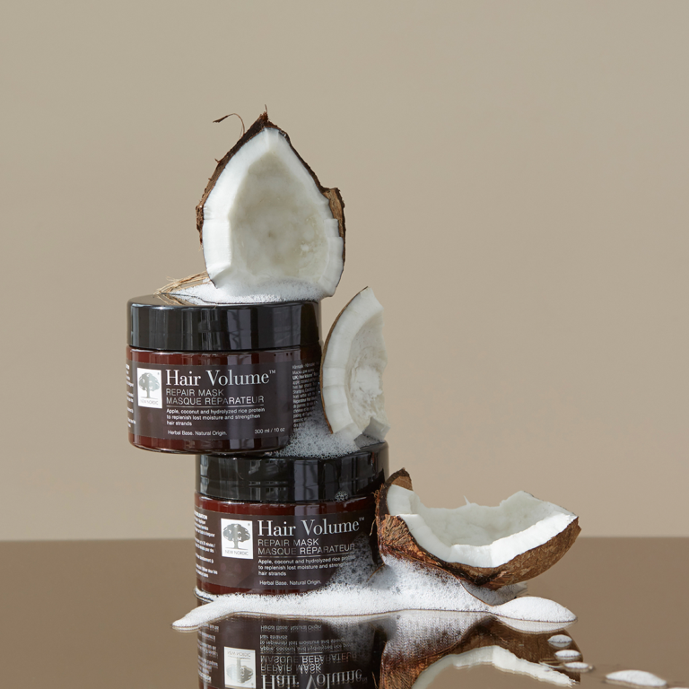 Hair Volume™ Repair Mask shown with fresh coconut on a light brown background.