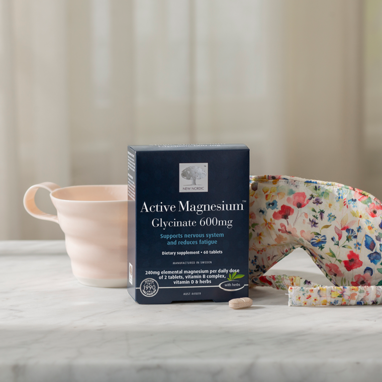 The Active Magnesium™ Glycinate package displayed with a sleeping mask and a light pink tea cup.
