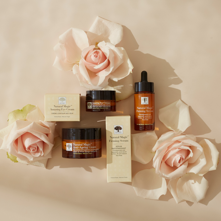 The Natural Magic™ skincare range displayed on a light beige background with light pink roses.