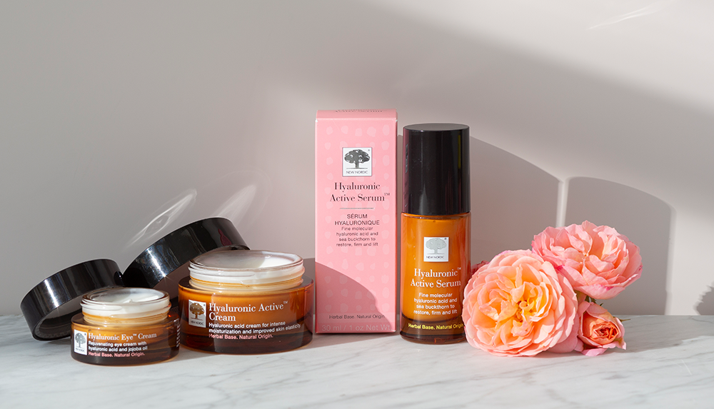 a group of our Hyaluronic Active bottles and a box with a pink box and a pink flower