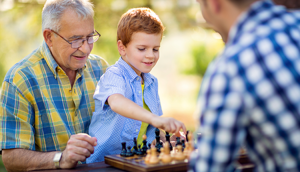 a grandpa and kid playing chess