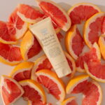 Herbal Joy™ Anti-Ageing Hand Cream displayed with freshly cut grape fruit.