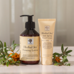 Herbal Joy™ Firming Lotion and Herbal Joy™ Anti-Ageing Hand Cream surrounded by fresh, orange sea buckthorn.