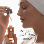Woman holding the Pigment Clear™ Serum bottle, highlighting skincare use and confidence.