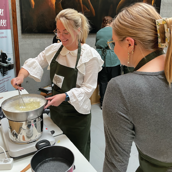 Woman experimenting with herbs at a herbal school event.