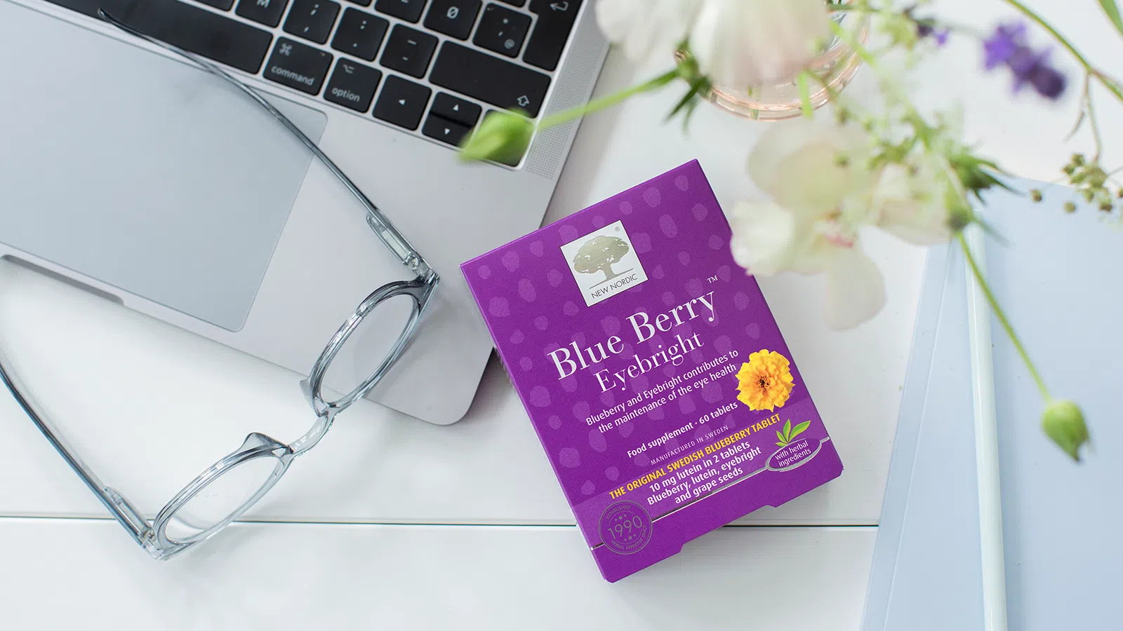 Blue Berry™ Eyebright Tablets 15 A pack og Blue Berry tablets on a table with a laptop and a pair of classes