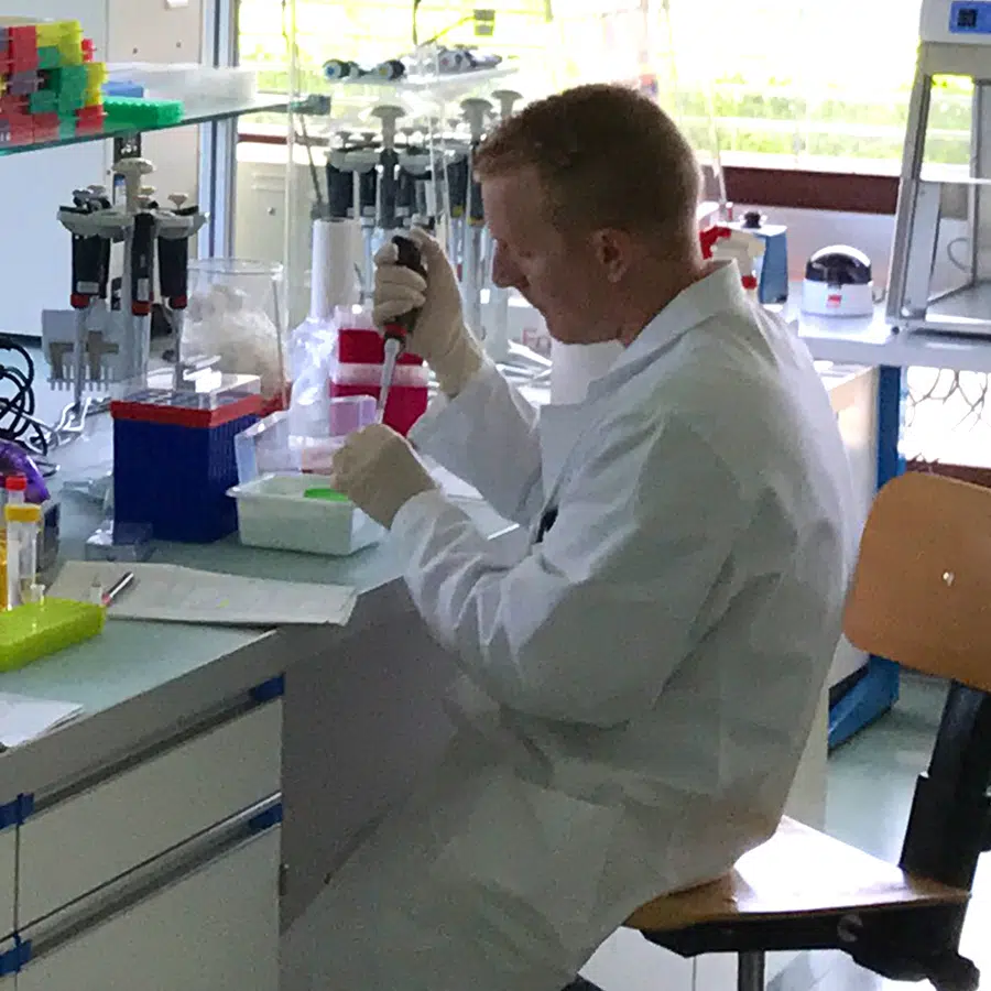 Laboratory technician using a pipette while working with samples in a research laboratory.
