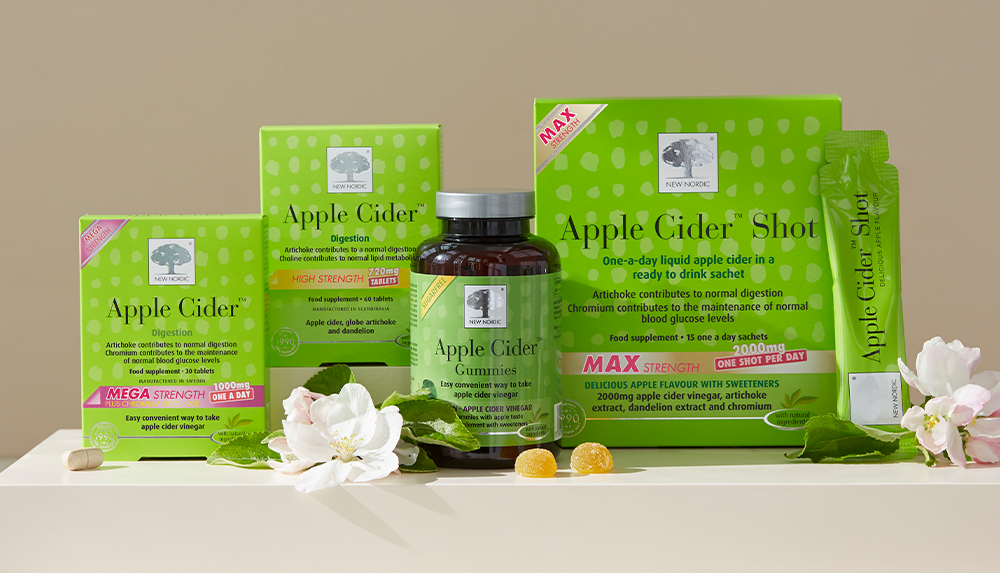 New Nordic Apple Cider™ digestion range, including tablets, gummies and Apple Cider™ Shot, displayed with apple blossom and leaves.